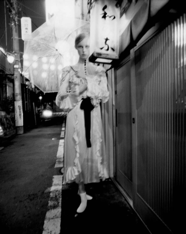 Tim Walker for UK Vogue December 2016 Rianne van Rompaey in white dress in alley